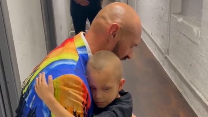 World champion Tyson Fury prays with cancer suffering child