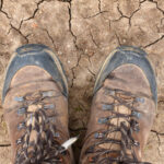 Hiking boots on dry desert soil