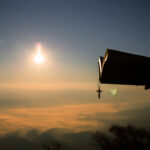 Silhouette of human hand holding bible and cross, the background